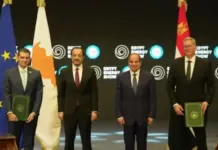 Egypt Eyes Cypriot Gas Development through Cronos Field FID Four men in suits pose on stage with flags (EU and national flags) and green folders at the Egypt Energy Show.