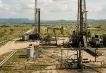 Venezuela Introduces New Oil Regulations to End Monopoly Oil drilling site with derricks, pumps, and pipelines in a flat rural field.